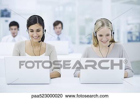 Telemarketers working in call center, smiling View Large Photo Image Stock Image - Telemarketers working in call center, smiling. Fotosearch