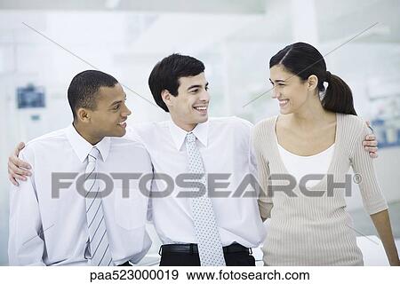 Stock Photo - Three professionals with arms around each other's shoulders, smiling, portrait. Fotosearch