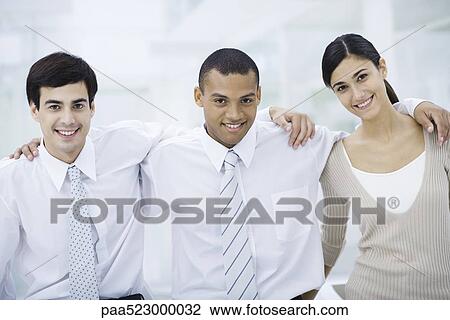 Three young professionals with arms around each other's shoulders, smiling at camera View Large Photo Image Stock Image - Three young professionals with arms around each other's shoulders, smiling at camera. Fotosearch