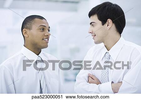 Stock Image - Two young businessmen chatting. Fotosearch