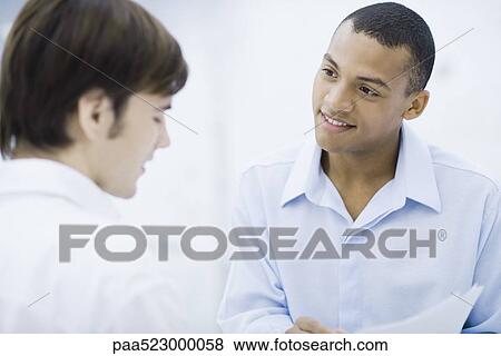 Young professional men face to face, smiling View Large Photo Image Stock Photo - Young professional men face to face, smiling. Fotosearch