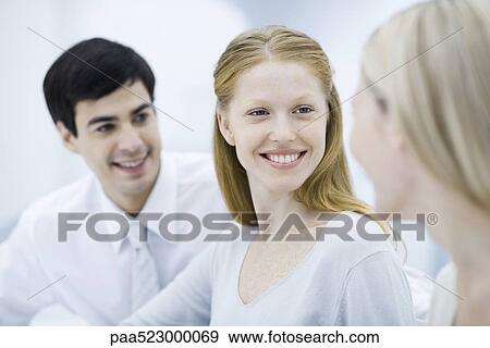 Young professional woman smiling at colleague, close-up View Large Photo Image Stock Photo - Young professional woman smiling at colleague, close-up. Fotosearch