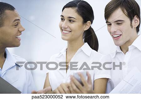 Young woman showing male colleagues her cell phone, smiling View Large Photo Image Stock Image - Young woman showing male colleagues her cell phone, smiling. Fotosearch