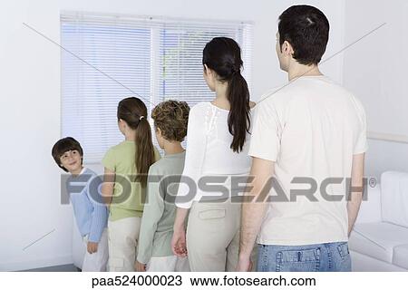 Family lined up shortest to tallest, youngest boy looking over shoulder at rest of family View Large Photo Image Stock Image - Family lined up shortest to tallest, youngest boy looking over shoulder at rest of family. Fotosearch