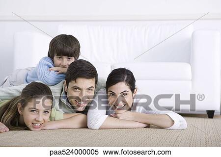 Family lying together on floor, son lying on his father's back, all smiling at camera View Large Photo Image Stock Photography - Family lying together on floor, son lying on his father's back, all smiling at camera. Fotosearch