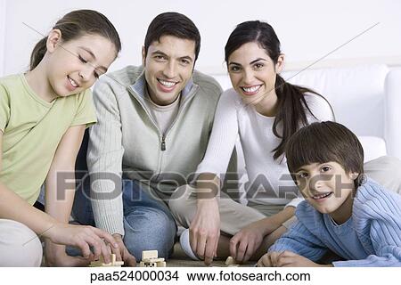 Picture - Family playing dominoes together, smiling. Fotosearch