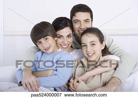 Stock Photo - Father embracing his wife and two children, all smiling at camera. Fotosearch