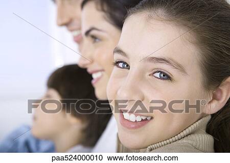 Girl sitting with family, smiling at camera, close-up View Large Photo Image Stock Image - Girl sitting with family, smiling at camera, close-up. Fotosearch