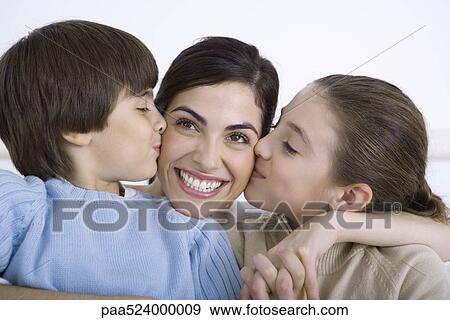 Mother being kissed on each cheek by young daughter and son, smiling View Large Photo Image Stock Photo - Mother being kissed on each cheek by young daughter and son, smiling. Fotosearch