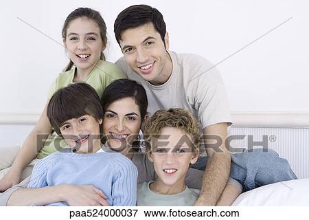 Stock Photo - Parents and three children smiling at camera, portrait. Fotosearch
