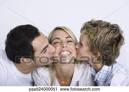 Smiling woman being kissed on each cheek by her husband and young son View Large Photo Image Stock Image - Smiling woman being kissed on each cheek by her husband and young son. Fotosearch
