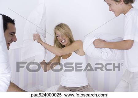 Woman having pillow fight with her husband and young son View Large Photo Image Stock Photography - Woman having pillow fight with her husband and young son. Fotosearch