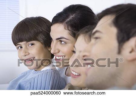 Stock Image - Young boy spending time with his family, smiling at camera. Fotosearch