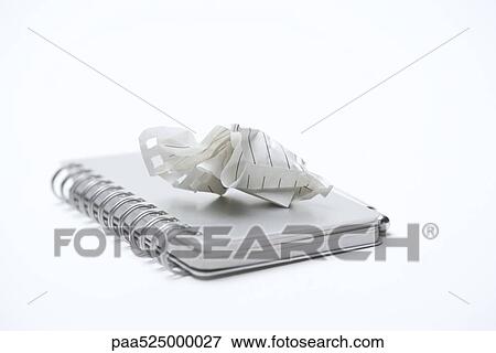 Crumpled paper resting on cover of closed notebook, close-up View Large Photo Image Stock Photo - Crumpled paper resting on cover of closed notebook, close-up. Fotosearch
