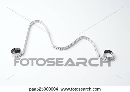 Measuring tape, coiled at either end, arranged to mimic line graph, high angle view View Large Photo Image Picture - Measuring tape, coiled at either end, arranged to mimic line graph, high angle view. Fotosearch