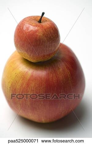 Small red apple on top of larger apple View Large Photo Image Stock Image - Small red apple on top of larger apple. Fotosearch
