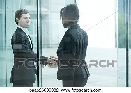 Businessman and businesswoman meet and shake hands at building entrance View Large Photo Image Stock Image - Businessman and businesswoman meet and shake hands at building entrance. Fotosearch