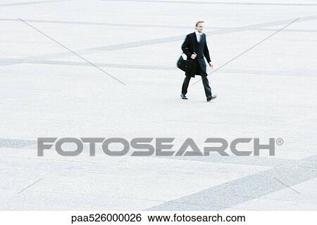 Businessman hurrying across public square View Large Photo Image Stock Photograph - Businessman hurrying across public square. Fotosearch