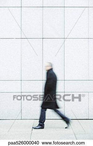 Businessman walking alone hands in pockets down sidewalk View Large Photo Image Stock Image - Businessman walking alone hands in pockets down sidewalk. Fotosearch