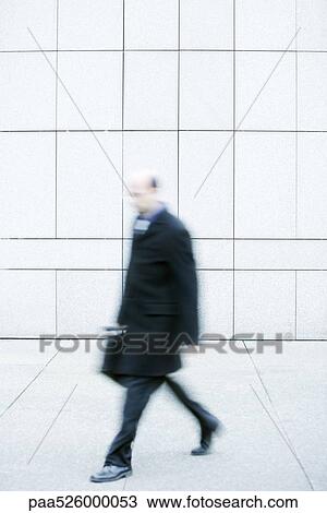 Businessman walking on sidewalk View Large Photo Image Stock Image - Businessman walking on sidewalk. Fotosearch