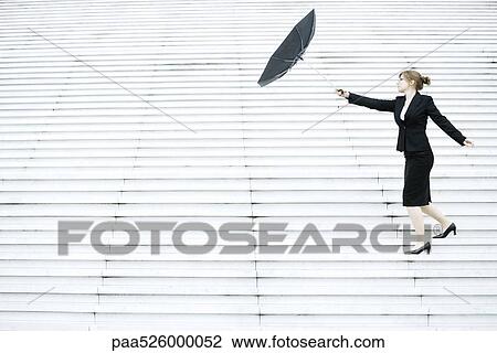 Businesswoman struggling with umbrella in wind View Large Photo Image Stock Image - Businesswoman struggling with umbrella in wind. Fotosearch