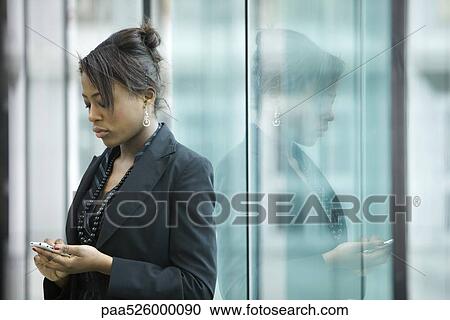 Businesswoman using cell phone, looking down View Large Photo Image Stock Image - Businesswoman using cell phone, looking down. Fotosearch