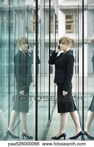 Businesswoman using cell phone, looking nervously at camera View Large Photo Image Stock Photograph - Businesswoman using cell phone, looking nervously at camera. Fotosearch