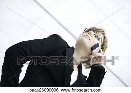 Businesswoman using cell phone, looking away View Large Photo Image Stock Photograph - Businesswoman using cell phone, looking away. Fotosearch