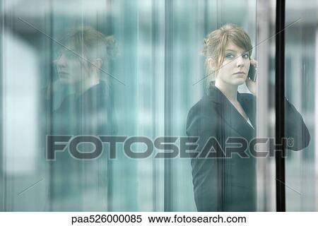 Businesswoman using cell phone, looking away View Large Photo Image Stock Photography - Businesswoman using cell phone, looking away. Fotosearch