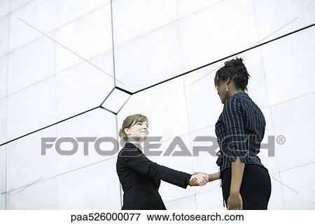 Stock Photo - Businesswomen meeting and shaking hands. Fotosearch