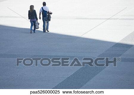 Stock Photography - Couple walking together across public square. Fotosearch