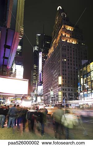 Stock Image - Nightlife scene on Broadway near Times Square in New York City. Fotosearch