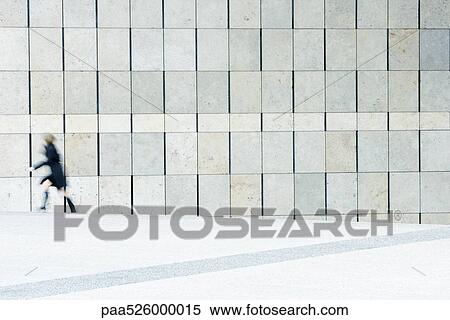 Stock Photography - Woman hurrying from top of stairs down sidewalk. Fotosearch