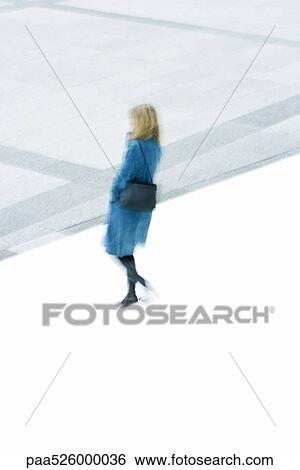 Woman in blue overcoat descending stairs View Large Photo Image Stock Photograph - Woman in blue overcoat descending stairs. Fotosearch