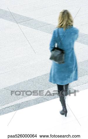 Woman in blue overcoat descending steps outdoors View Large Photo Image Picture - Woman in blue overcoat descending steps outdoors. Fotosearch