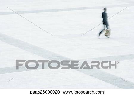 Woman walking across public square View Large Photo Image Stock Image - Woman walking across public square. Fotosearch