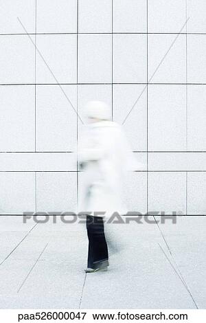 Woman wearing white coat, white knit hat and white knit scarf walking down sidewalk View Large Photo Image Stock Photo - Woman wearing white coat, white knit hat and white knit scarf walking down sidewalk. Fotosearch
