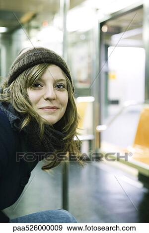 Young woman riding subway, smiling at camera View Large Photo Image Stock Photo - Young woman riding subway, smiling at camera. Fotosearch