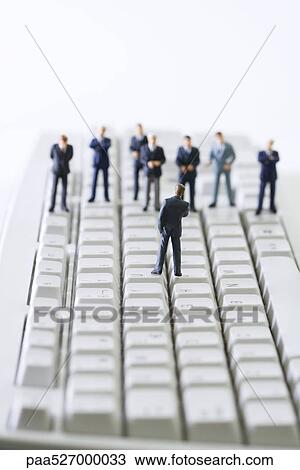 Miniature businessman addressing group of colleagues on computer keyboard View Large Photo Image Stock Image - Miniature businessman addressing group of colleagues on computer keyboard. Fotosearch