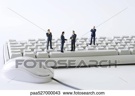 Miniature businessmen standing on computer keyboard View Large Photo Image Stock Image - Miniature businessmen standing on computer keyboard. Fotosearch
