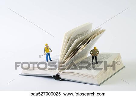 Miniature construction workers standing on open book View Large Photo Image Stock Photography - Miniature construction workers standing on open book. Fotosearch