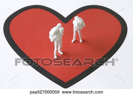 Miniature figures standing on large heart View Large Photo Image Stock Photo - Miniature figures standing on large heart. Fotosearch