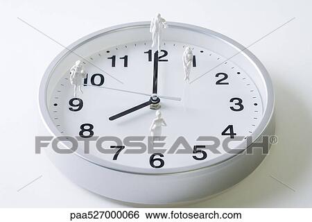 Miniature figures standing on surface of clock View Large Photo Image Stock Photograph - Miniature figures standing on surface of clock. Fotosearch