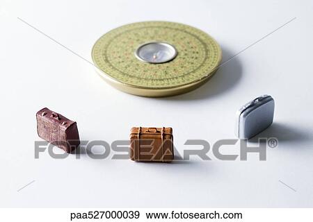 Miniature suitcases arranged around Feng Shui compass View Large Photo Image Stock Photo - Miniature suitcases arranged around Feng Shui compass. Fotosearch