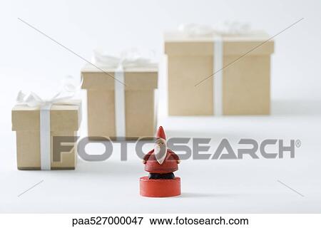 Santa Claus figurine standing in front of Christmas gifts View Large Photo Image Stock Photo - Santa Claus figurine standing in front of Christmas gifts. Fotosearch