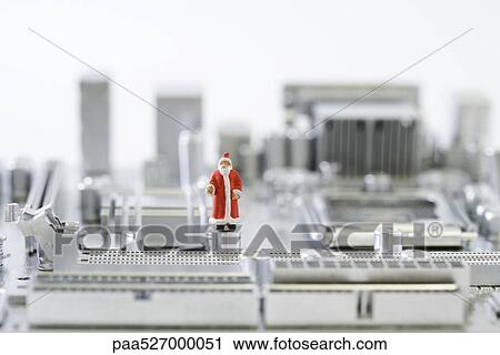 Stock Image - Santa Claus figurine standing on computer motherboard. Fotosearch