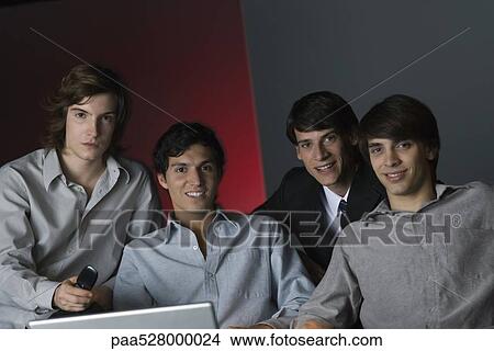 Picture - Professional men sitting side by side, smiling at camera, portrait. Fotosearch