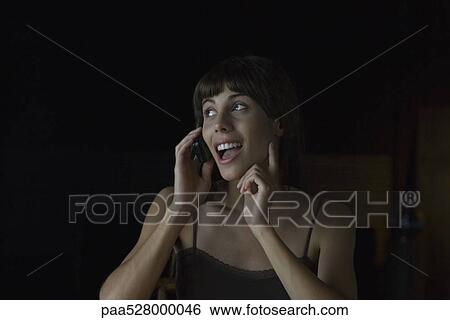 Woman happily talking on cell phone, looking away, gesturing View Large Photo Image Stock Photograph - Woman happily talking on cell phone, looking away, gesturing . Fotosearch