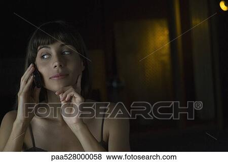 Woman talking on cell phone, hand under chin, looking away View Large Photo Image Stock Photo - Woman talking on cell phone, hand under chin, looking away. Fotosearch