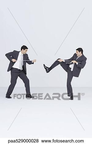 Businessman having tug-of-war with self View Large Photo Image Stock Photo - Businessman having tug-of-war with self. Fotosearch